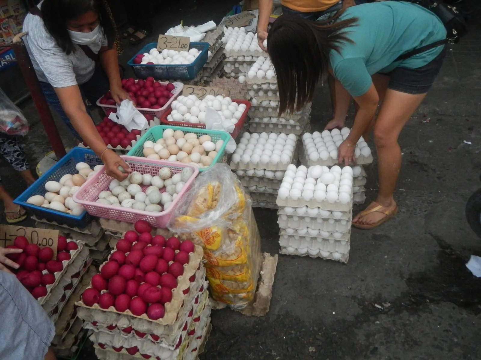 Trays of white chicken eggs, red salted eggs and duck eggs for sale at a market stall in Bulacan